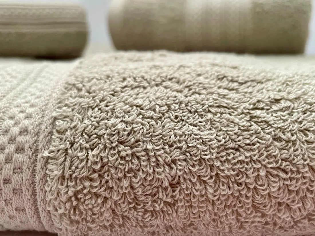 Soft grey cotton towels folded in natural light